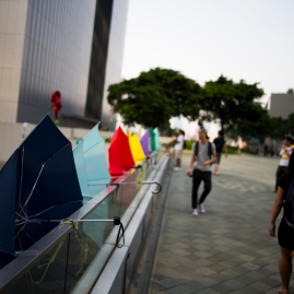 Umbrellas, the unlikely symbol of Hong Kong's largest civil disobedience movement in decades, are strapped to the railing of a pedestrian overpass, which connects Tamar Park with Admiralty Shopping Center, in central Hong Kong. (Photo: Adam McCauley)
